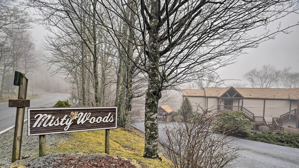 A sign for 'Misty Woods' with a gravel path and trees in the background. - Deck & Grill: Modern Sugar Mtn Escape! (Banner Elk)