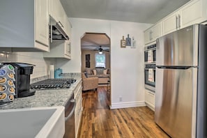 A modern kitchen with stainless steel appliances, white cabinetry, and a wooden floor. - Walk to Dtwn Littleton: Updated Pet-friendly Home (Littleton)