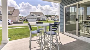 A patio with a table and chairs, a glass door, and a view of neighboring houses. - Spacious House: Pool Access Nearby & 4 Mi to Beach (Millville)