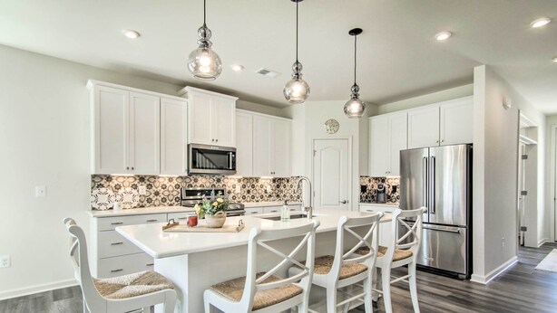 A modern kitchen with white cabinetry, a central island with seating, stainless steel appliances, and decorative backsplash. - Spacious House: Pool Access Nearby & 4 Mi to Beach (Millville)