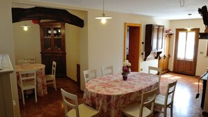 A dining area with a round table and chairs, a cabinet, and a door leading to another room. - Sleeping in the Prosecco Hills. House suitable for families or groups of friends. (Combai)
