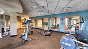 A gym with various exercise equipment, including treadmills and elliptical machines, and a mirrored wall. - Lakefront Lago Vista Condo w/ Resort Amenities! (Leander)