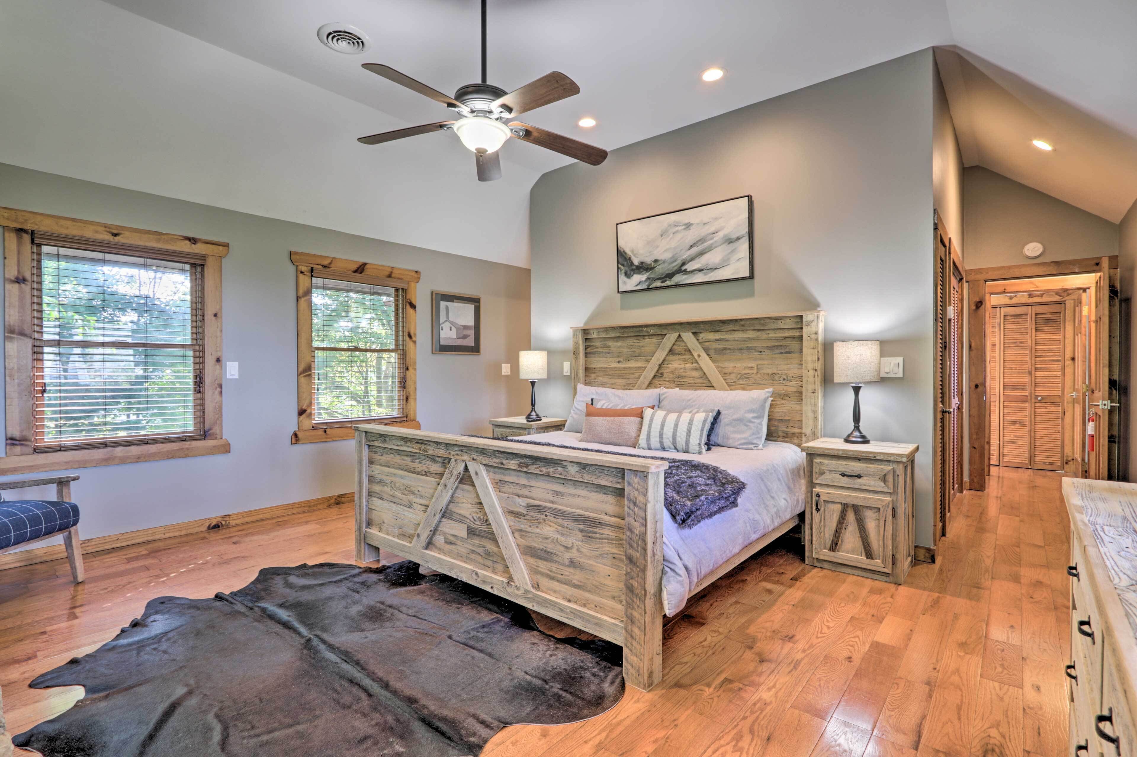 A bedroom with a wooden bed, a ceiling fan, and a large window with blinds.