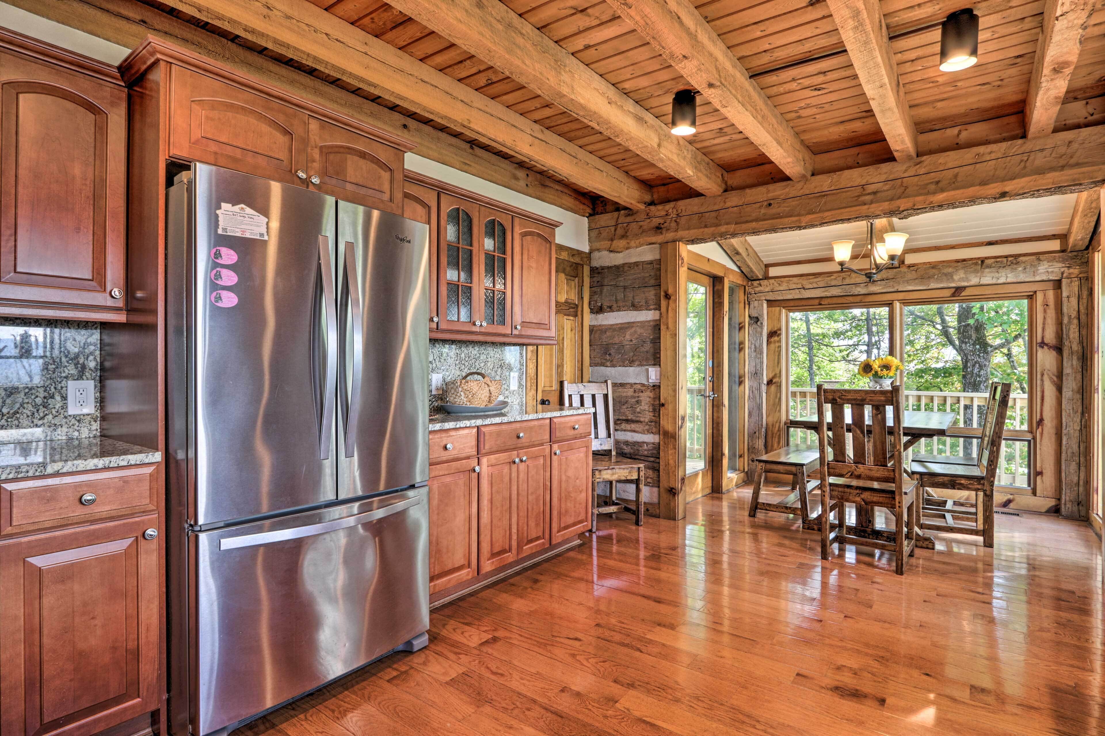 A kitchen with wooden cabinets, a stainless steel refrigerator, and a dining area with a wooden table and chairs.