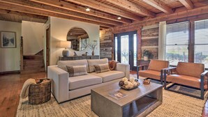 A cozy living room with a sofa, armchairs, a coffee table, and a fireplace. - Deck & Hot Tub: Mtn-view Gatlinburg Cabin (Gatlinburg)