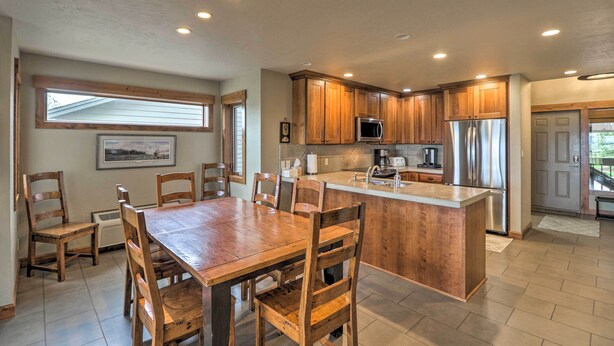 A modern kitchen with wooden cabinets, a central island, and built-in appliances. - Expansive Bigfork Resort Retreat on Flathead Lake! (Bigfork)