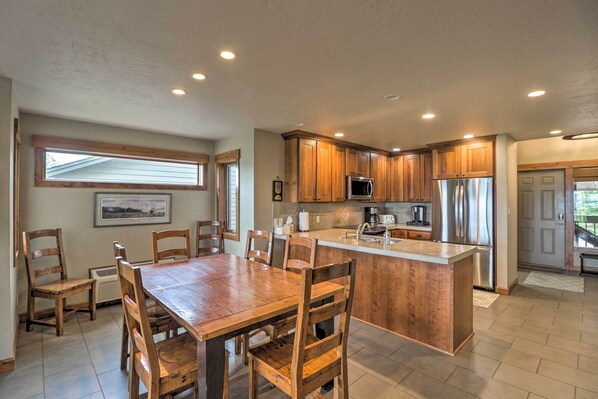 A modern kitchen with wooden cabinets, a central island, and built-in appliances. - Expansive Bigfork Resort Retreat on Flathead Lake! (Bigfork)