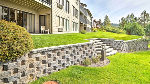 A multi-story residential building with balconies, large windows, and a well-maintained lawn. - Expansive Bigfork Resort Retreat on Flathead Lake! (Bigfork)