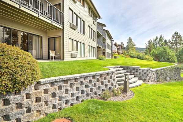 A multi-story residential building with balconies, large windows, and a well-maintained lawn. - Expansive Bigfork Resort Retreat on Flathead Lake! (Bigfork)