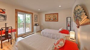 A bedroom with two beds, a desk, and a chair. There is a balcony with a view of greenery. - Yonkers Apt w/ Balcony: Walk to Train Station! (Yonkers)