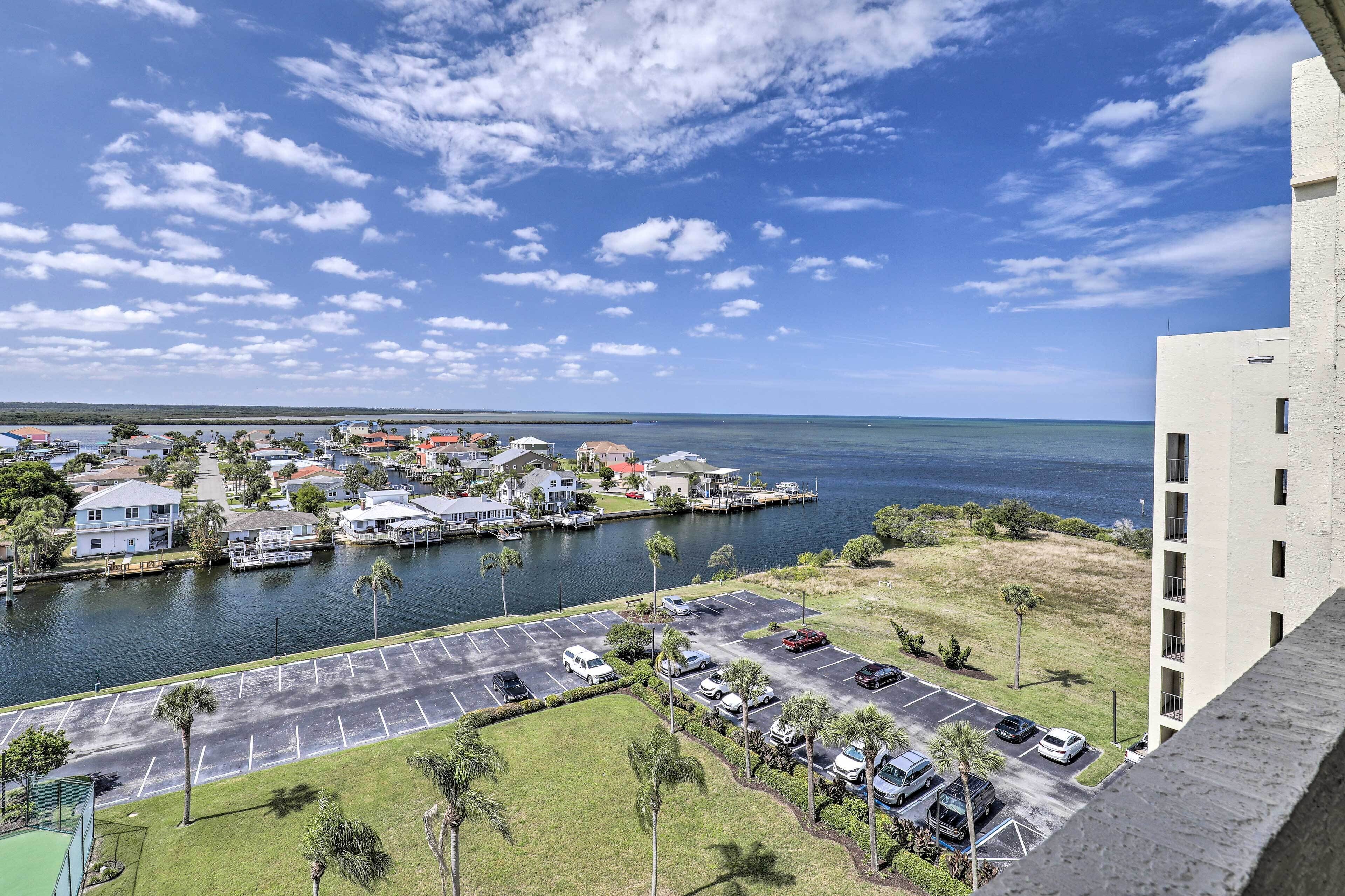 A coastal view with a marina, parking lot, and buildings.