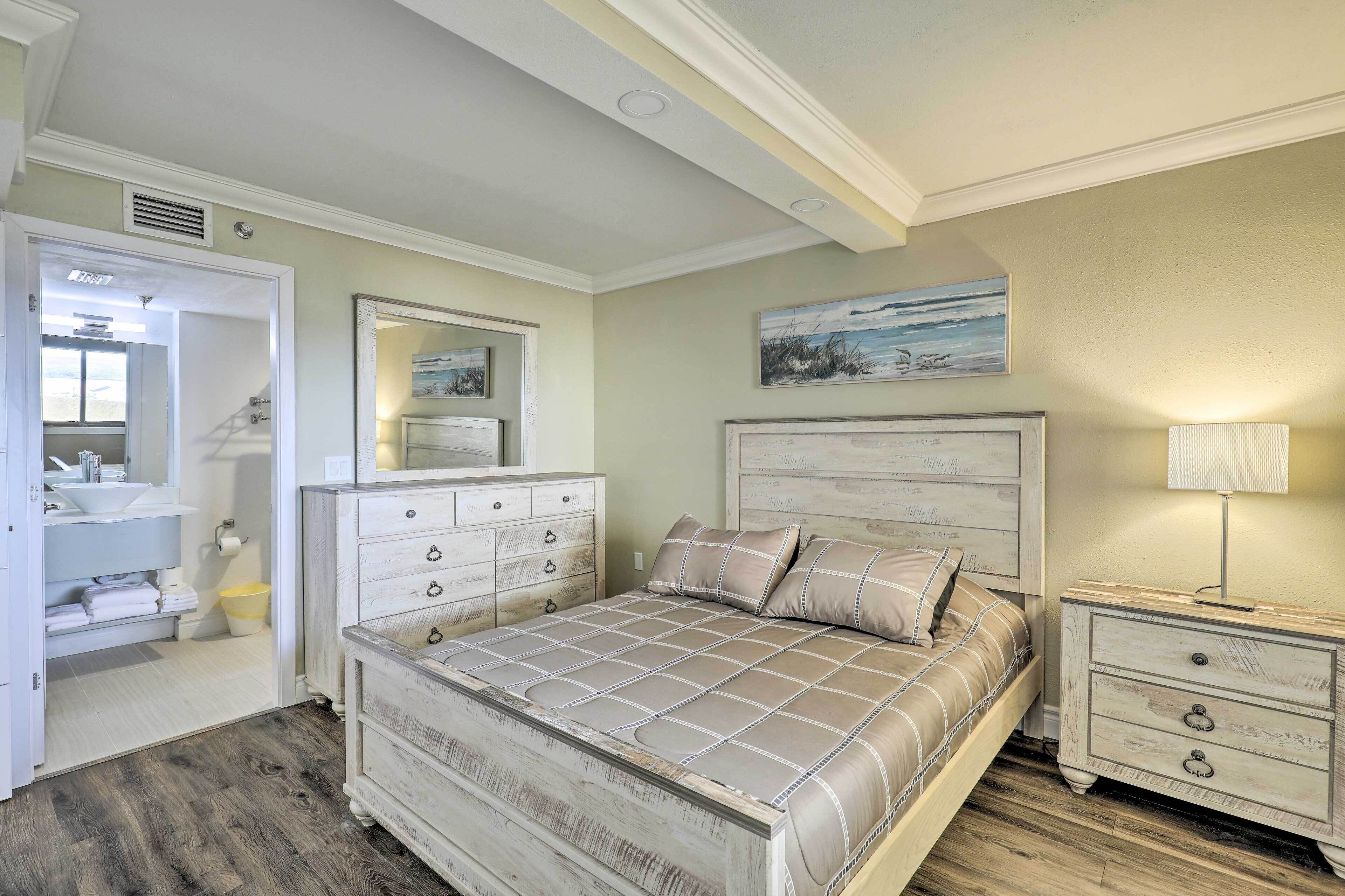 A bedroom with a bed, dresser, nightstand, and a mirror.