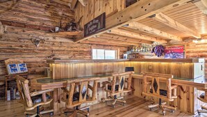 A rustic wooden bar area with a sign reading "Belle River Outfitters" and a Budweiser sign. - Secluded Belle Fourche Cabin: Group Friendly! (Belle Fourche)