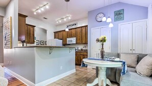 A kitchen with wooden cabinets, a white microwave, and a sign that says "KITCHEN". - Ocean Springs Home w/ Fire Pit & Game Room! (Biloxi)