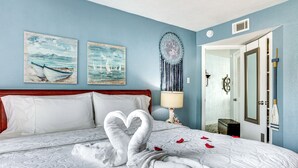 A hotel room with a bed, two wall paintings, a dreamcatcher, and a mirror. - Resort-style Lake Conroe Retreat w/ Balcony & View (Willis)