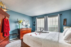 Relax in a romantic setting with a large bed, dresser, and cozy plant.