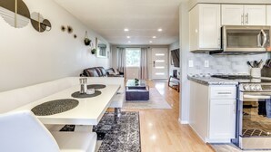 A modern kitchen with white cabinets, a stainless steel microwave, and a built-in oven.
