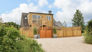 Una casa de madera con camino de grava y valla de madera.