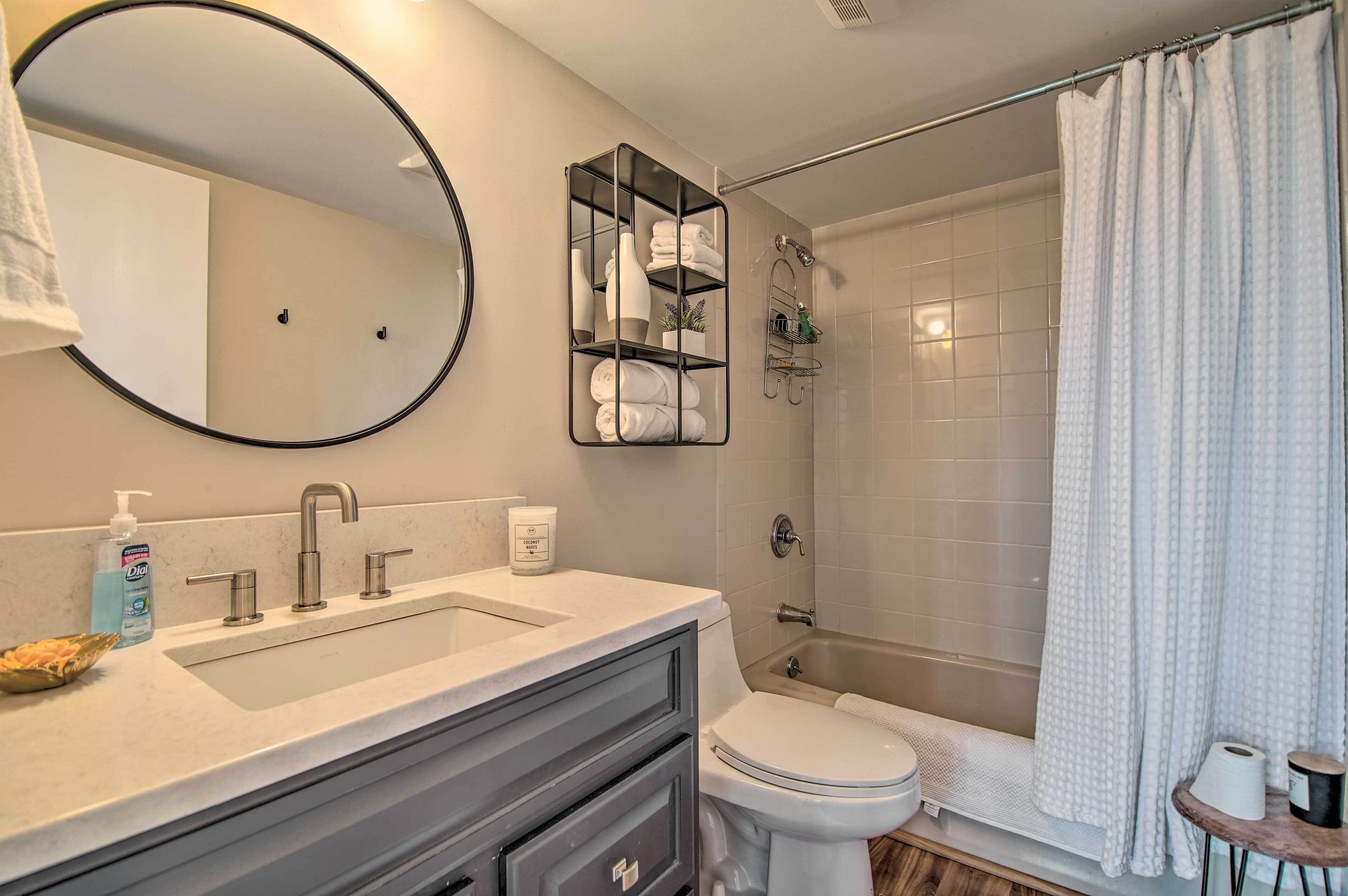 Un baño moderno con lavamanos, inodoro y ducha.