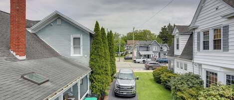 A residential street with houses, a truck, and a clear sky.