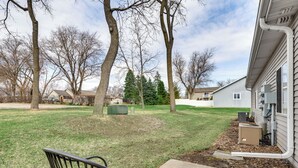 A residential outdoor area with a lawn, trees, and a house. - Lake Mills Retreat: 1 Mi to Beaches & Dining! (Lake Mills)