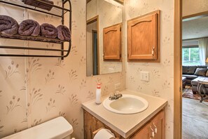 A bathroom with a toilet, sink, and towel rack.