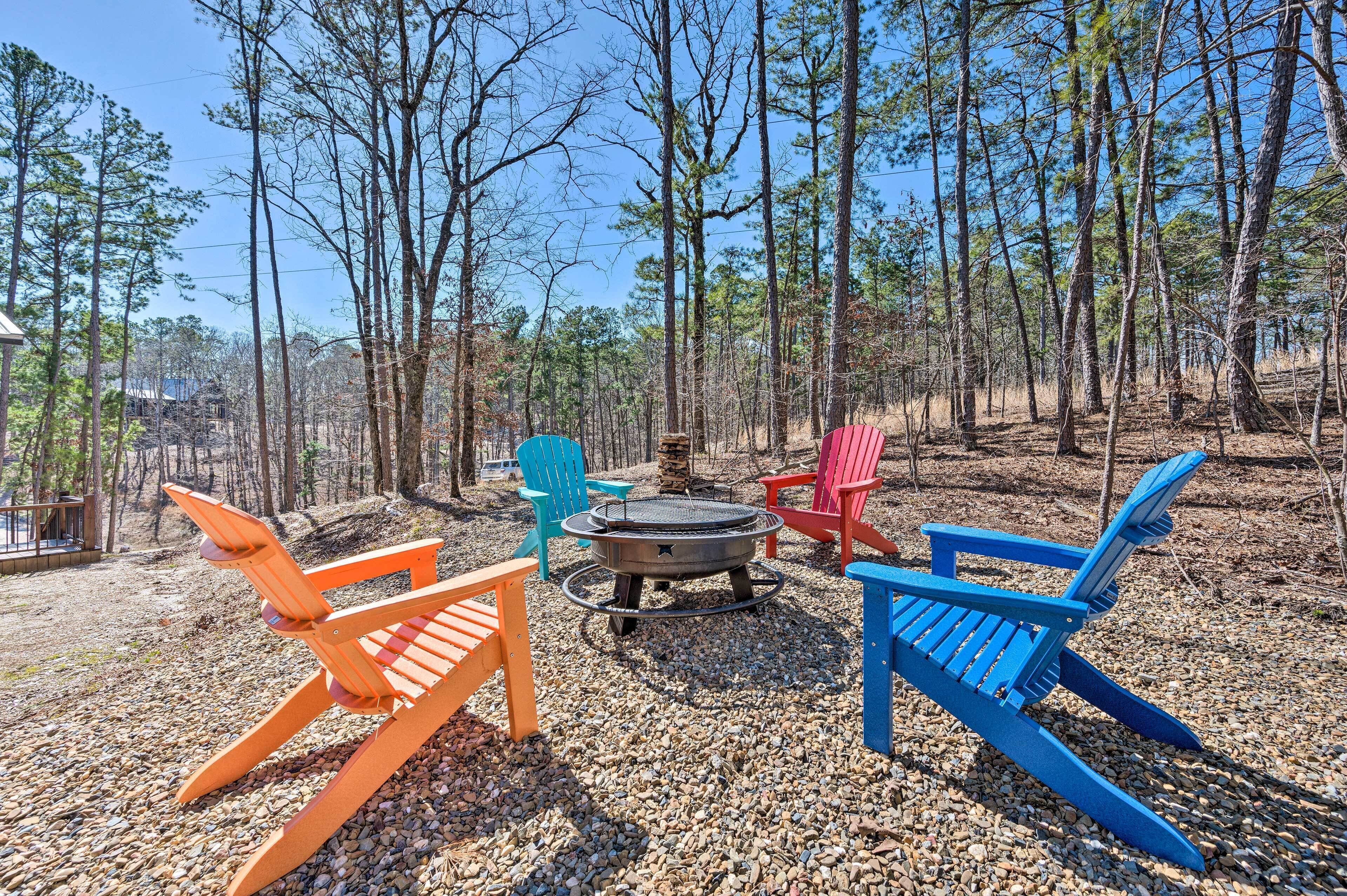 An outdoor seating area with colorful Adirondack chairs, a fire pit, and a gravel ground.