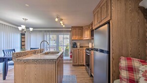 A modern kitchen with wooden cabinets, a granite countertop, a stainless steel refrigerator, and a built-in oven. - Central Hummelstown Apt: 4 Miles to Hershey Park! (Hummelstown)