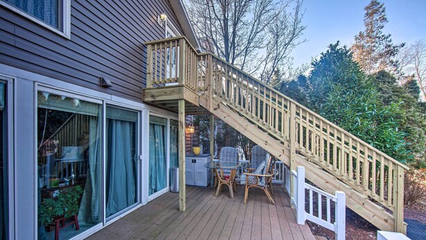 A wooden deck with a staircase leading to a covered area, a glass door, and a small table with chairs. - Central Hummelstown Apt: 4 Miles to Hershey Park! (Hummelstown)