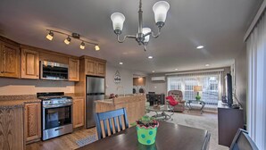A modern kitchen with wooden cabinets, stainless steel appliances, and a dining area with a table and chairs. - Central Hummelstown Apt: 4 Miles to Hershey Park! (Hummelstown)