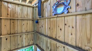 A wooden interior with a ceiling beam structure, a mounted pipe, and a decorative mirror. - Ocean Isle Beach Escape - Centrally Located! (Ocean Isle Beach)