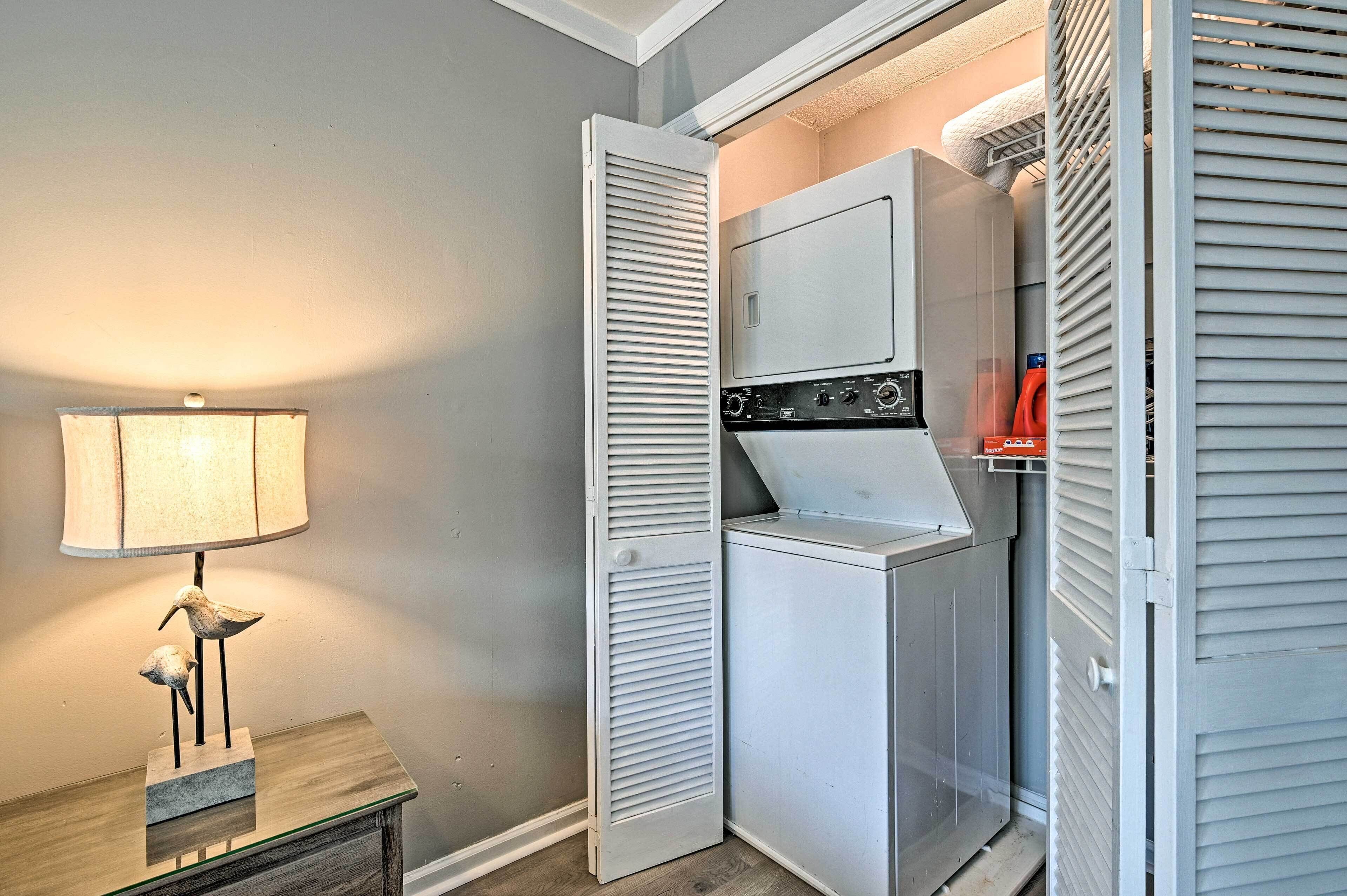 A laundry room with a washing machine, dryer, and ironing board.