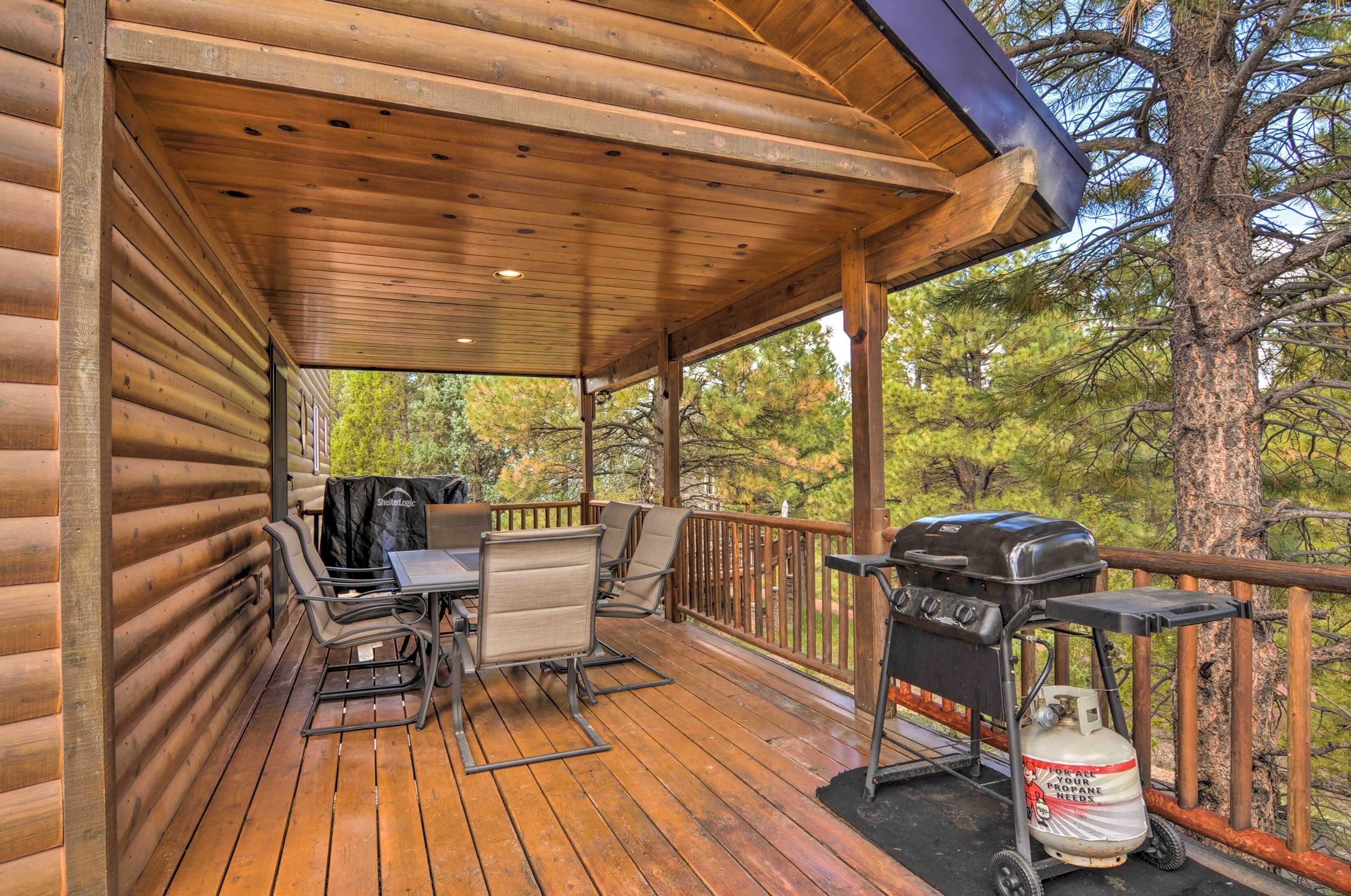 A covered wooden deck with a grill and seating area.