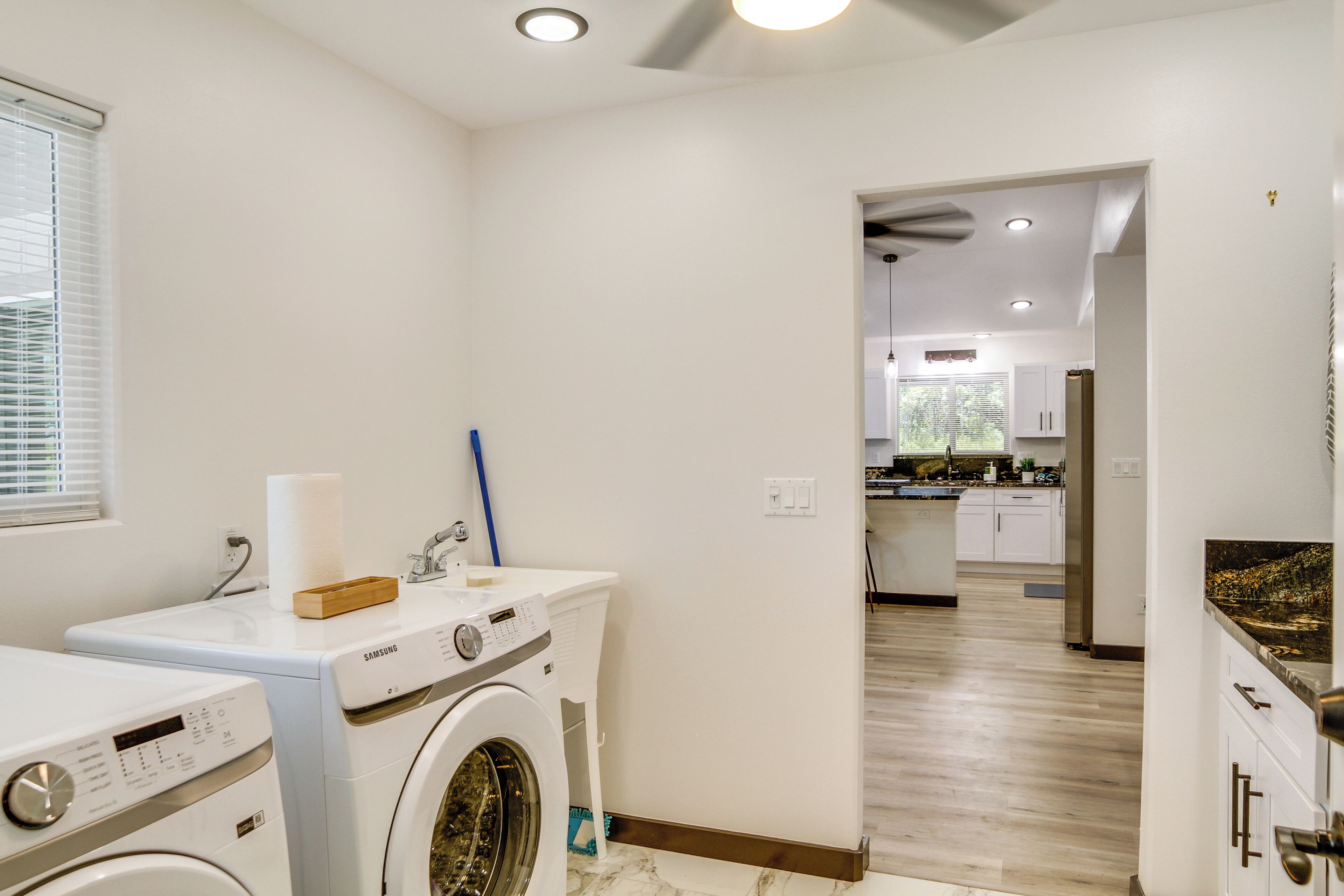 A laundry room with a Samsung washing machine, a dryer, and a wooden box on the counter.