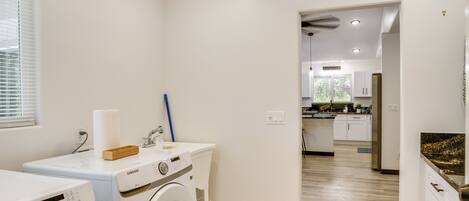 A laundry room with a Samsung washing machine, a dryer, and a wooden box on the counter.