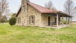 Un bâtiment en pierre avec un toit rouge et un porche abrité.