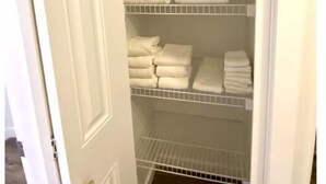 A white closet with multiple shelves holding folded white towels. - 3 Bedroom Townhome in Osoyoos with views! VII (Osoyoos)