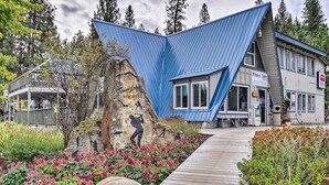 A uniquely designed building with a blue roof and a wooden deck leading to the entrance.