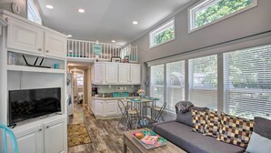 A spacious living area with a TV, sofa, and dining table. - Cozy Broken Bow Getaway w/ Fire Pit, 5 Mi to Lake! (Broken Bow)