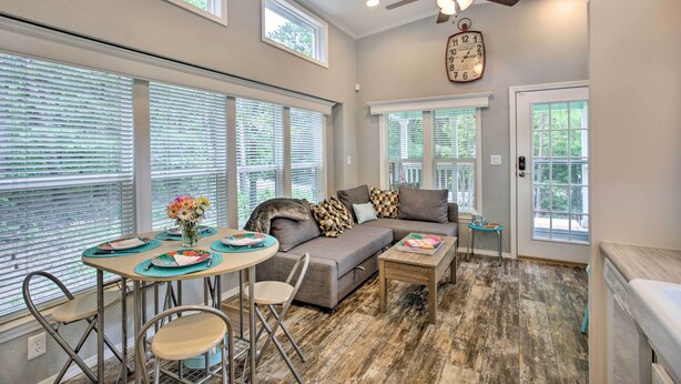 A spacious living room with a gray sofa, a dining table with chairs, and a ceiling fan. - Cozy Broken Bow Getaway w/ Fire Pit, 5 Mi to Lake! (Broken Bow)
