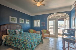 Relax in this inviting room featuring a large bed, ceiling fan, and comfortable seating area.