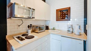 A modern kitchen with white cabinets, a microwave, a toaster, a coffee maker, and a small refrigerator. - Studio w/ Marina Views: 15 Mi To Everglades! (Naples)