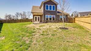 A two-story house with a front porch, a fenced backyard, and a clear sky. - Nolensville Home w/ Free Wifi: 20 Mi to Nashville! (Nolensville)