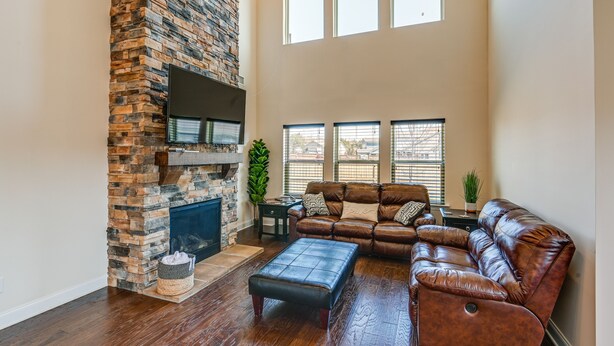 A spacious living room with a stone fireplace, leather sofa, and large windows. - Nolensville Home w/ Free Wifi: 20 Mi to Nashville! (Nolensville)