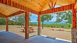 A covered outdoor area with picnic tables and stone pillars, overlooking a scenic landscape. - Talihina Retreat w/ Kiamichi River Access! (Talihina)