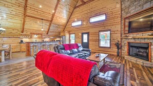 A log cabin interior with a fireplace, leather seating, and a stone fireplace surround. - Talihina Retreat w/ Kiamichi River Access! (Talihina)