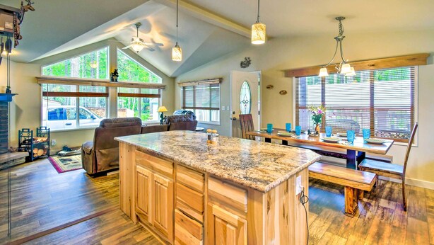 A spacious kitchen with a large island, wooden cabinets, and a dining area with a bench. - Awesome Hoodsport Cabin - Nearby Hiking Areas (Hoodsport)