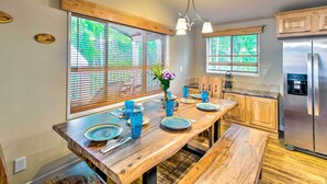 A kitchen with wooden countertops, a stainless steel refrigerator, and a dining area with a wooden bench and blue glassware. - Awesome Hoodsport Cabin - Nearby Hiking Areas (Hoodsport)