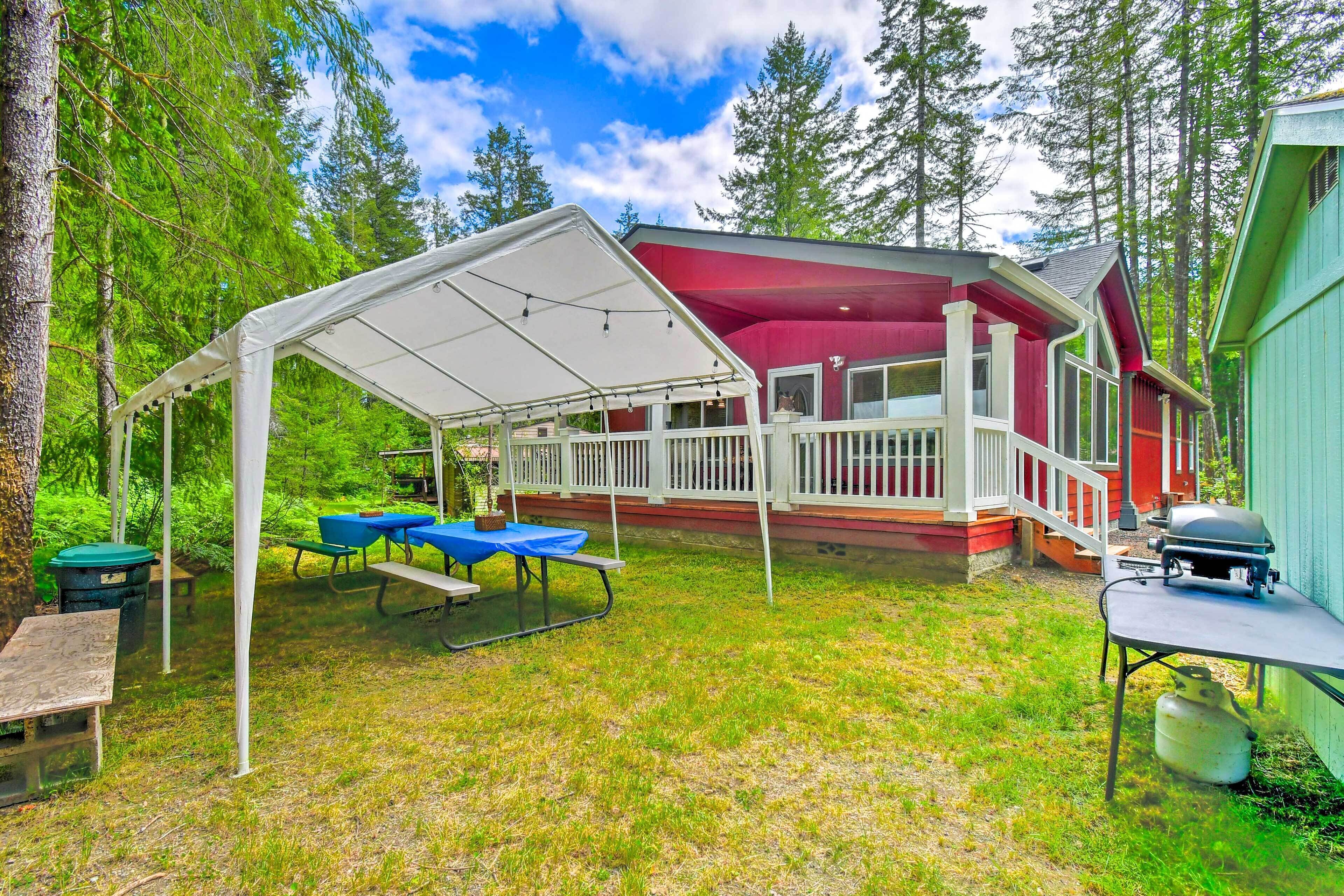 A covered patio area with picnic tables and a barbecue grill.