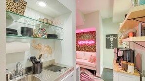 A modern kitchen with a stainless steel sink, glass shelves, and a zebra-patterned rug. - Houston Vacation Rental ~ 1 Mi to Downtown! (Houston)